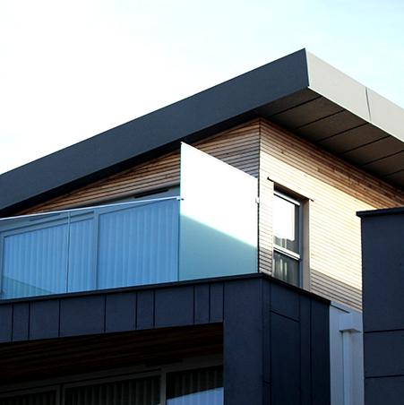 A modern house with a dark roof edge and timber cladding