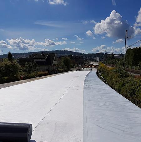 A wide strip of white membrane laid along a new embankment