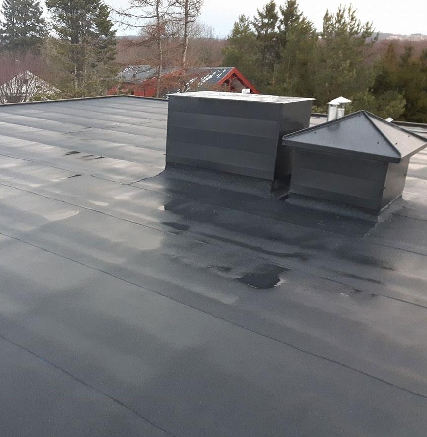 Ventilation housings on a dark, newly laid flat roof