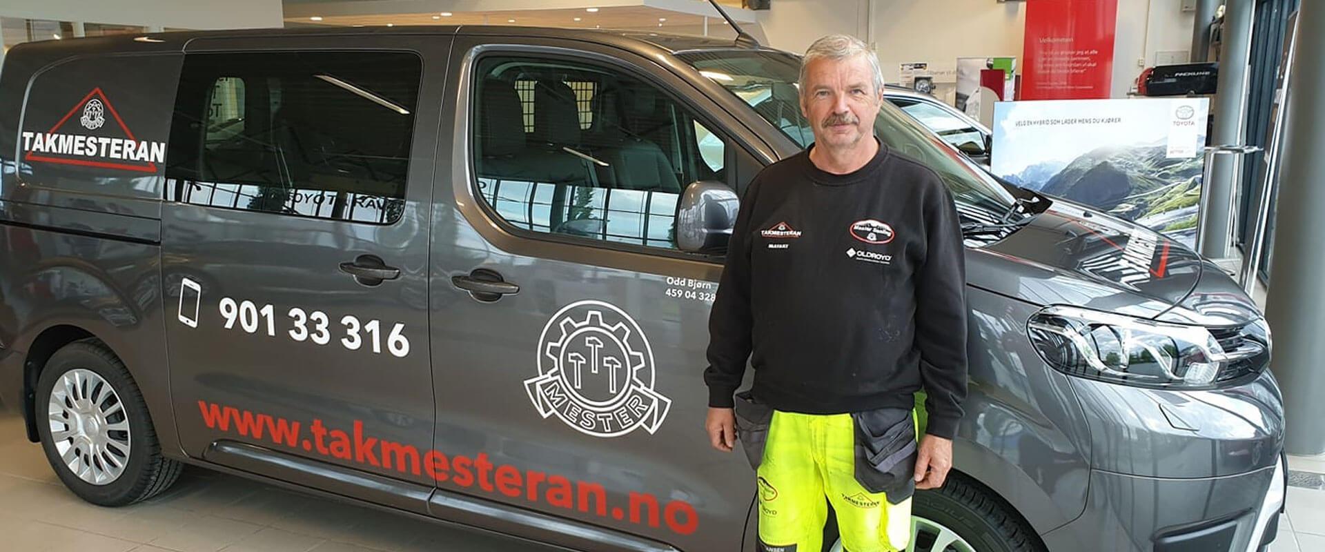 A Takmesteran van with the logo and phone number on the side, one of the team standing beside it